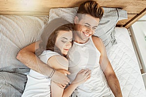 Young loving couple in pajamas in the bed