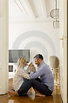 Young loving couple sitting on the floor with digital tablet