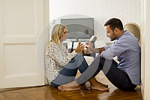 Young loving couple sitting on the floor with digital tablet