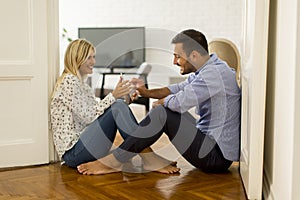 Young loving couple sitting on the floor with digital tablet