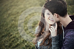 Young loving couple sitting on the grass