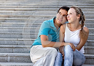 Young loving couple sitting on stairs
