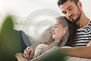 young loving couple sleeping on couch and embracing