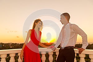 Young loving couple standing next to the stone gazebo with the s