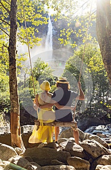 Young loving couple swing on a swing in the woods. Very romantic situation