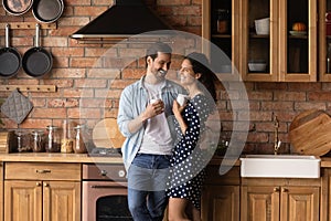 Young loving family couple drink coffee at modern kitchen