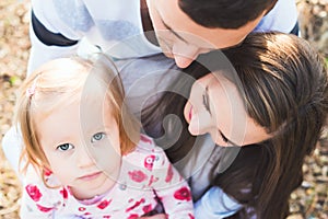 Young loving family of three, authentic candid outdoors family portrait. photo