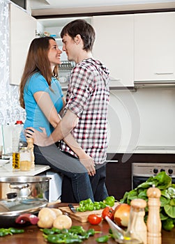 Young loving man and girl having flirt at domestic kitchen