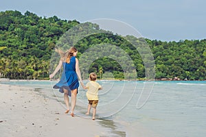 Young loving mother and her little son playing on the beach