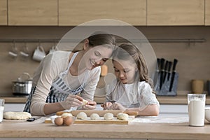 Young loving mother teach her preschooler daughter to cook