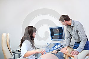 Young loving pregnant couple visiting doctor together