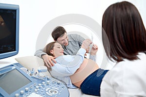 Young loving pregnant couple visiting doctor together