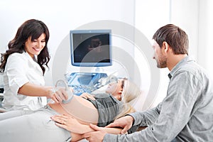 Young loving pregnant couple visiting doctor together