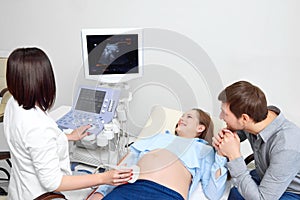 Young loving pregnant couple visiting doctor together