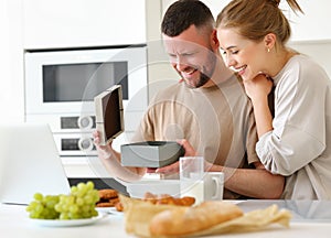 Young loving wife making surprise for husband on Birthday while standing in kitchen at home