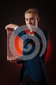 A young magician guy is holding cards in his hands