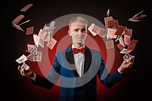 A young magician guy is holding cards in his hands