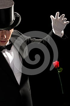 Young magician performing red rose photo