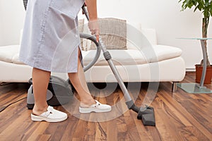 Young maid cleaning floor