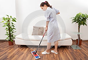 Young maid cleaning floor