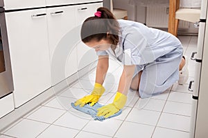 Young maid cleaning floor