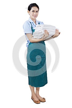 Young maid holding bedding and towels