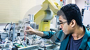 A young Malay engineering student with spectacles working in the lab
