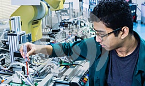 A young Malay engineering student with spectacles working in the lab