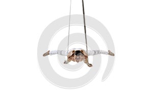 Young male acrobat, circus athlete isolated on white studio background. Training perfect balanced in flight