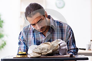 Young male archaeologist studying ancient african stonemask