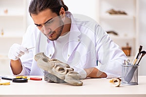 Young male archaeologist studying ancient african stonemask