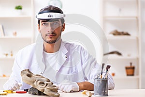 Young male archaeologist studying ancient african stonemask