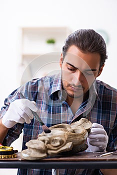 Young male archaeologist studying ancient african stonemask