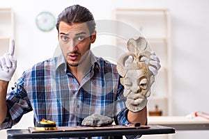 Young male archaeologist studying ancient african stonemask