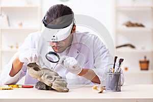 Young male archaeologist studying ancient african stonemask