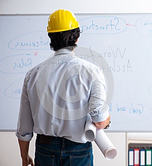 Young male architect in front of the whiteboard