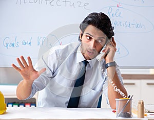 Young male architect in front of the whiteboard