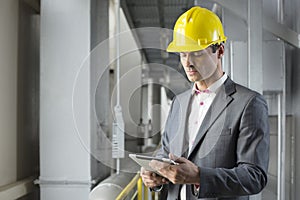 Young male architect using tablet computer in industry