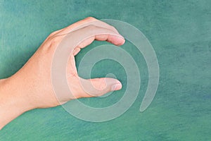 Young male Asian hand making letter C sign  on green background.