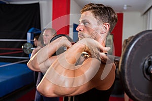 Young male athlete lifting barbell