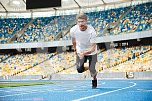 Young male athlete running on a racetrack