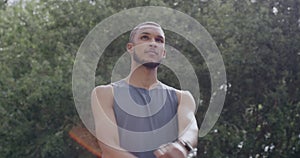 Young male athlete stretching his arms while standing outside. Young sportsman warming up his muscles during a workout