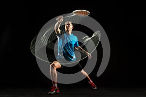 Young male badminton player over balck background