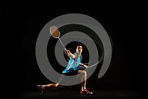 Young male badminton player over balck background