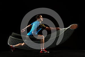 Young male badminton player over balck background