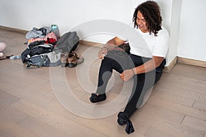 young male ballet dancer smiling preparing before class african american man getting ready putting on dance shoes and leotard