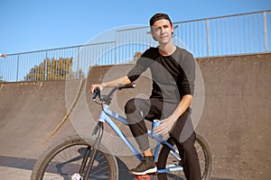 Young male bmx biker leisures on ramp in skatepark