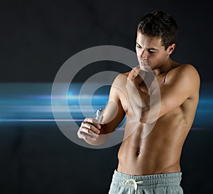 Young male bodybuilder applying pain relief gel