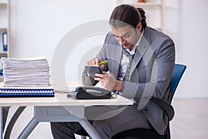 Young male bookkeeper calculating expences