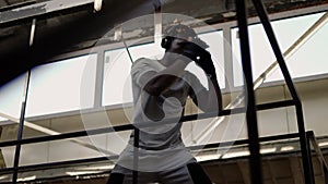 Young male boxer practicing shadow boxing around the metal structures, low angle view